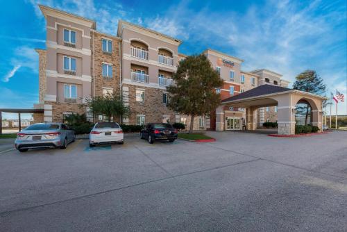 a hotel with cars parked in a parking lot at Comfort Suites Corpus Christi Central in Corpus Christi