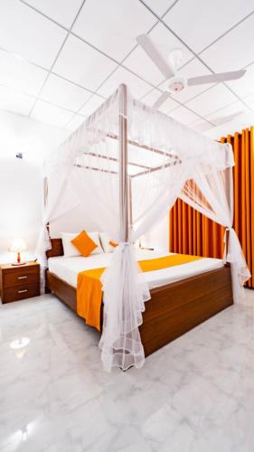 a bedroom with a bed with a mosquito net at Nimsara Lodge Sigiriya in Sigiriya
