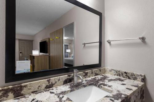 a bathroom with a sink and a large mirror at Days Inn by Wyndham Charleston WV in Charleston