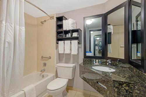 a bathroom with a toilet and a sink and a tub at Comfort Inn & Suites Carrollton in Carrollton