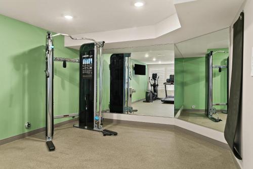 a gym with green walls and a mirror at WoodSpring Suites East Lansing - University Area in East Lansing