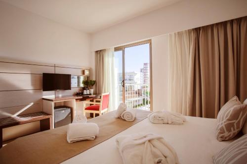 una camera d'albergo con un letto con asciugamani sopra di Hotel Puchet Ibiza a San Antonio