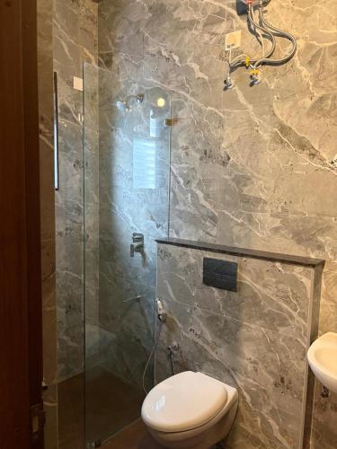 a bathroom with a toilet and a glass shower at Two Heart heaven in Covelong