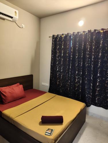 a bedroom with a bed with a black curtain at Two Heart heaven in Covelong