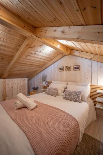a large white bed in a room with wooden ceilings at Villavender Boutique Suites in Netivot