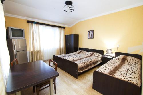 a hotel room with two beds and a table at Nick&David INN in Borjomi