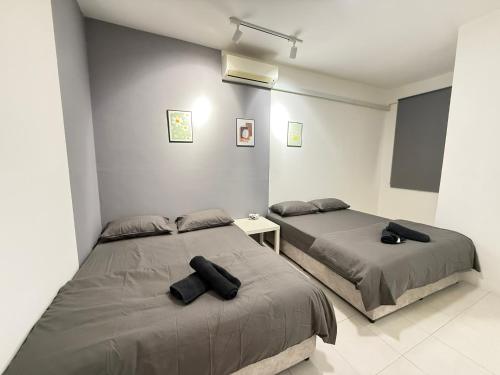 two beds in a white room with two black pillows at R3troHouse3 4BR 14PAX Near188Tower, HTAA, In Town in Kuantan