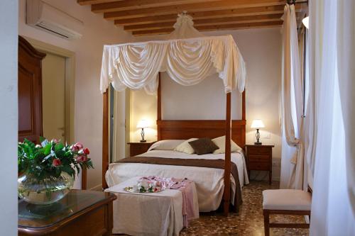 ヴェネツィアにあるB&B アル パラツェットのベッドルーム(天蓋付きベッド1台、テーブル付)