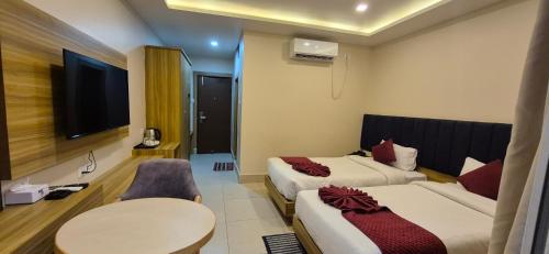 a hotel room with two beds and a table and a tv at Hotel Quick Twenty and Riverside Pvt Ltd in Amlekhganj