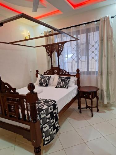 a bedroom with a canopy bed and a table at Serena10 in Mombasa