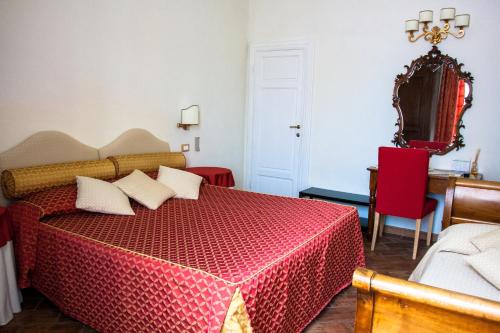 a bedroom with a red bed with white pillows at Il Mattino Ha L'Oro In Bocca in Pisa