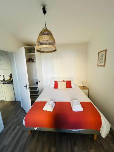 a bedroom with a large bed with a red blanket at Appartement proche université in Caen