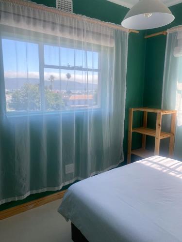 a bedroom with a bed and a large window at Number 5 Beau Rivage in Knysna