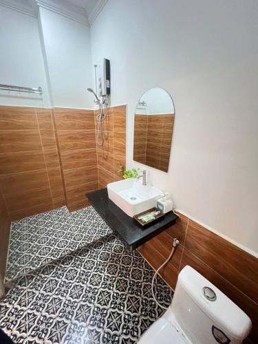 a bathroom with a sink and a mirror and a toilet at Grand Apsara Residence in Siem Reap