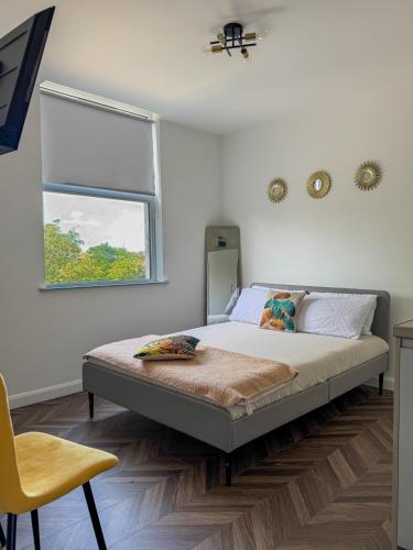 a bedroom with a bed and a window and a chair at Dalston Luxe Studios, 10 minutes away from Liverpool Train Station in London