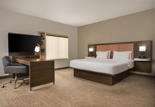 a hotel room with a bed and a desk and a computer at Hampton Inn & Suites - Mansfield in Mansfield