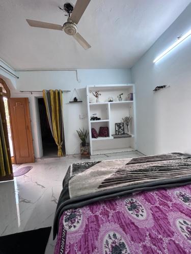 a bedroom with a bed and a ceiling fan at Shiva in Hāpur