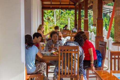a group of people sitting at a table in a restaurant at Satyodaya Educational Training Centre in Kandy