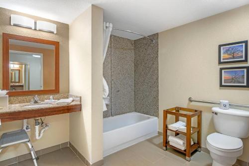 a bathroom with a toilet and a sink and a tub at Comfort Suites Brunswick in Brunswick