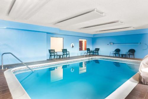 a pool in a hotel with blue walls and chairs at Quality Inn & Suites Niles in Niles