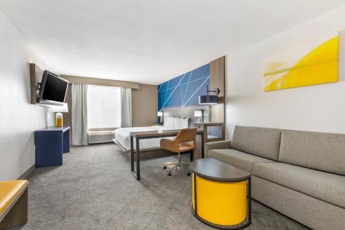 a hotel room with a couch and a bed at Comfort Inn & Suites Irving Las Colinas DFW in Irving