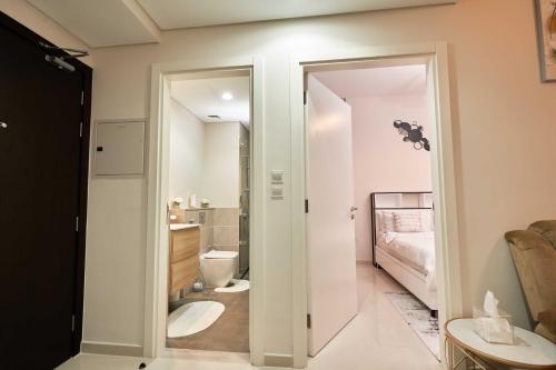 a room with a bathroom with a toilet and a bedroom at Cosy 1 Bedroom in Damac Hills | OFEX in Dubai