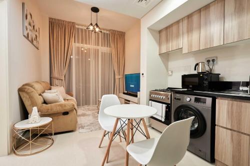a kitchen and living room with a table and chairs at Cosy 1 Bedroom in Damac Hills | OFEX in Dubai