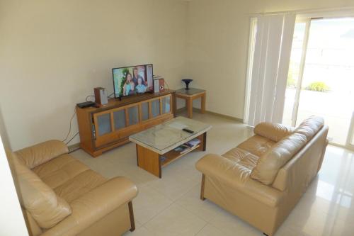 a living room with two couches and a tv at Seafront Unit 49 in Jurien Bay