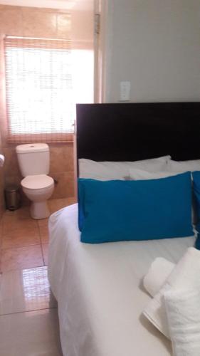 Un dormitorio con una cama con una almohada azul encima. en Valley Guest House, en Pretoria