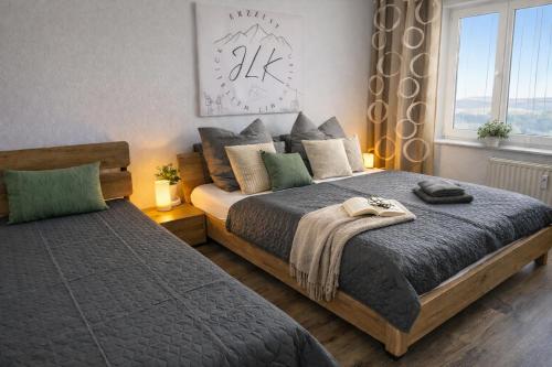 a bedroom with two beds and a window at ErzZeit Urlaub mit Weitblick in Schwarzenberg/Erzgebirge