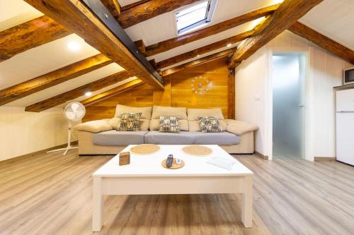 a living room with a couch and a table at Cozy Attic in the City Center of Soria in Soria