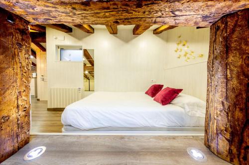 a bedroom with a white bed with red pillows at Cozy Attic in the City Center of Soria in Soria