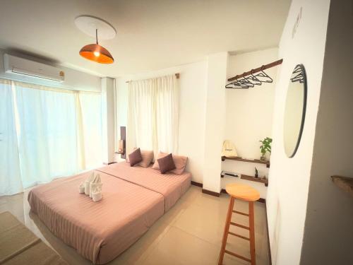 a bedroom with two beds and a stool in it at ปันสุขโฮมเทล Pansuk Hometel in Nakhon Phanom