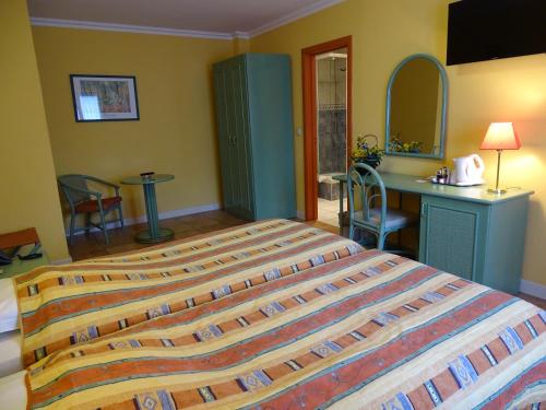a bedroom with a large bed and a desk at Hotel Le Relais de Pommard in Francorchamps