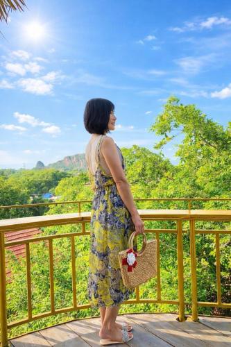 a woman standing on a deck looking out at the mountains at Trang An ViewPoint Homestay in Ninh Binh