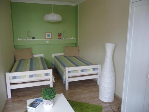 ein Zimmer mit 2 Betten und einer Vase darin in der Unterkunft Ferienwohnung Hüsken in Voerde