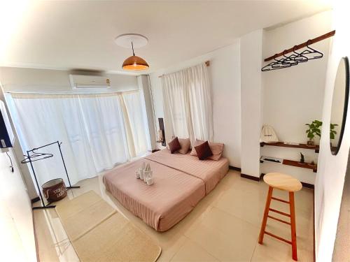 a bedroom with a bed and a stool in it at ปันสุขโฮมเทล Pansuk Hometel in Nakhon Phanom
