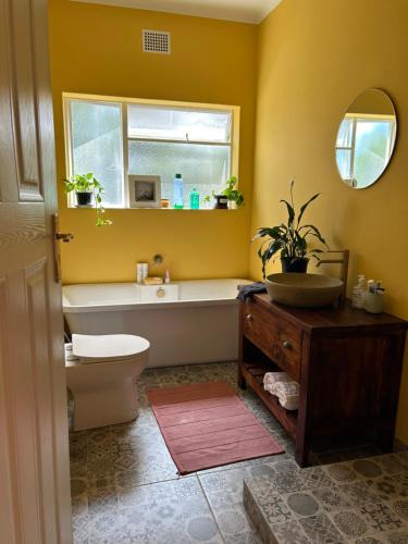 a bathroom with a toilet and a sink and a tub at Number 5 Beau Rivage in Knysna