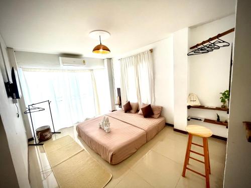 a bedroom with a bed and a stool in it at ปันสุขโฮมเทล Pansuk Hometel in Nakhon Phanom