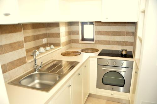 a small kitchen with a sink and a stove at Porta Barsento in Putignano