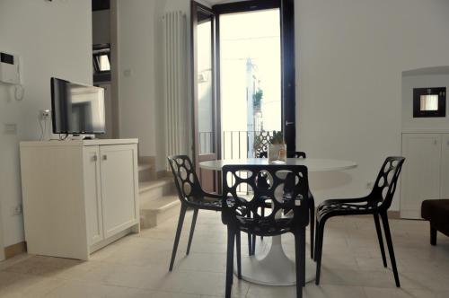 a dining room with a table and chairs and a television at Porta Barsento in Putignano