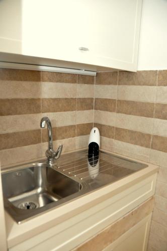 a stainless steel sink in a small kitchen at Porta Barsento in Putignano