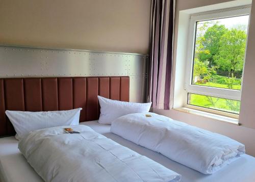 two white beds in a room with a window at Wildeshauser Hof in Wildeshausen