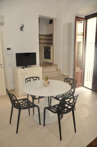 a dining room with a white table and chairs at Porta Barsento in Putignano