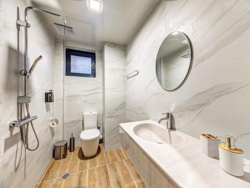 a white bathroom with a sink and a mirror at Къща за гости "Mirror Lake" in Smolyan