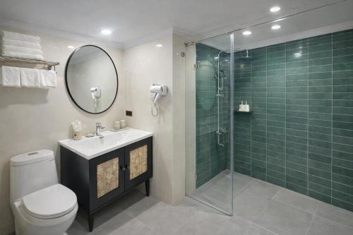 a bathroom with a shower and a toilet and a sink at The Emissary Hanoi Hotel & Spa in Hanoi
