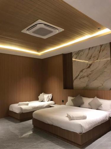 two beds in a hotel room with a ceiling with at Firdaus Cafe& Hotel in Ban Bo So