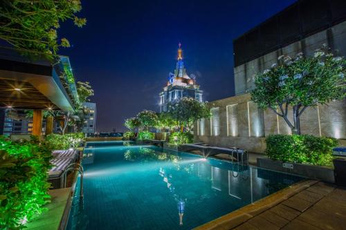 a swimming pool in front of a building with a tower at Oakwood Premier Prestige Bangalore in Bangalore