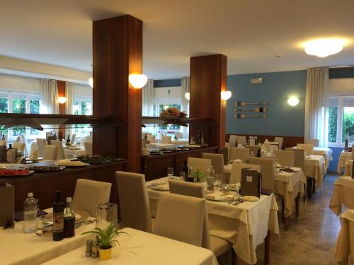 a dining room with white tables and chairs at Corallo Wellness Hotel in Diano Marina