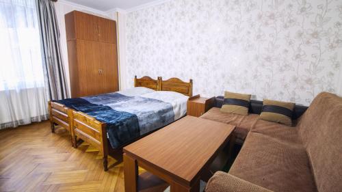 a living room with a couch and a bed at Nick&David INN in Borjomi